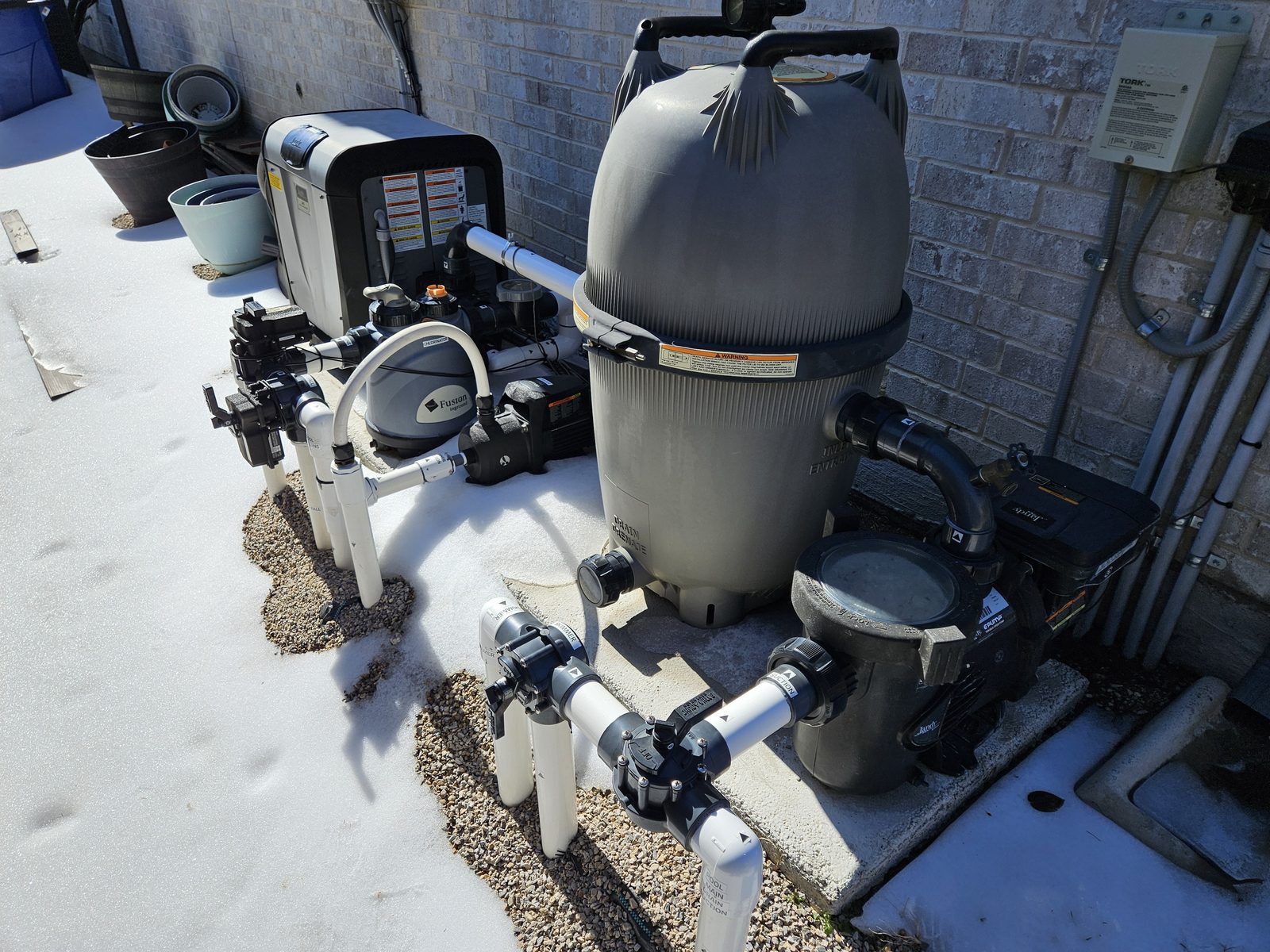 Pool filter tank and valve manifold on an equipment pad