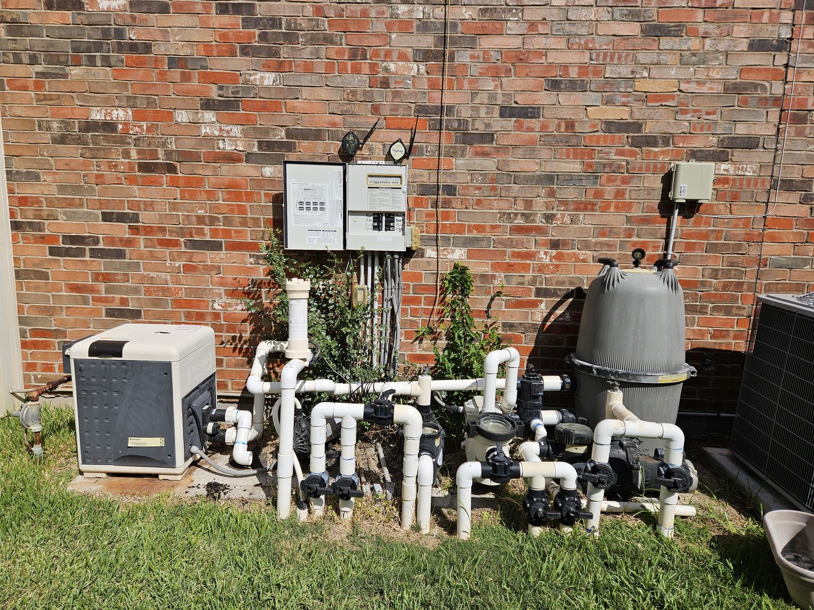 Pool heater, filter and plumbing installed on a backyard equipment pad