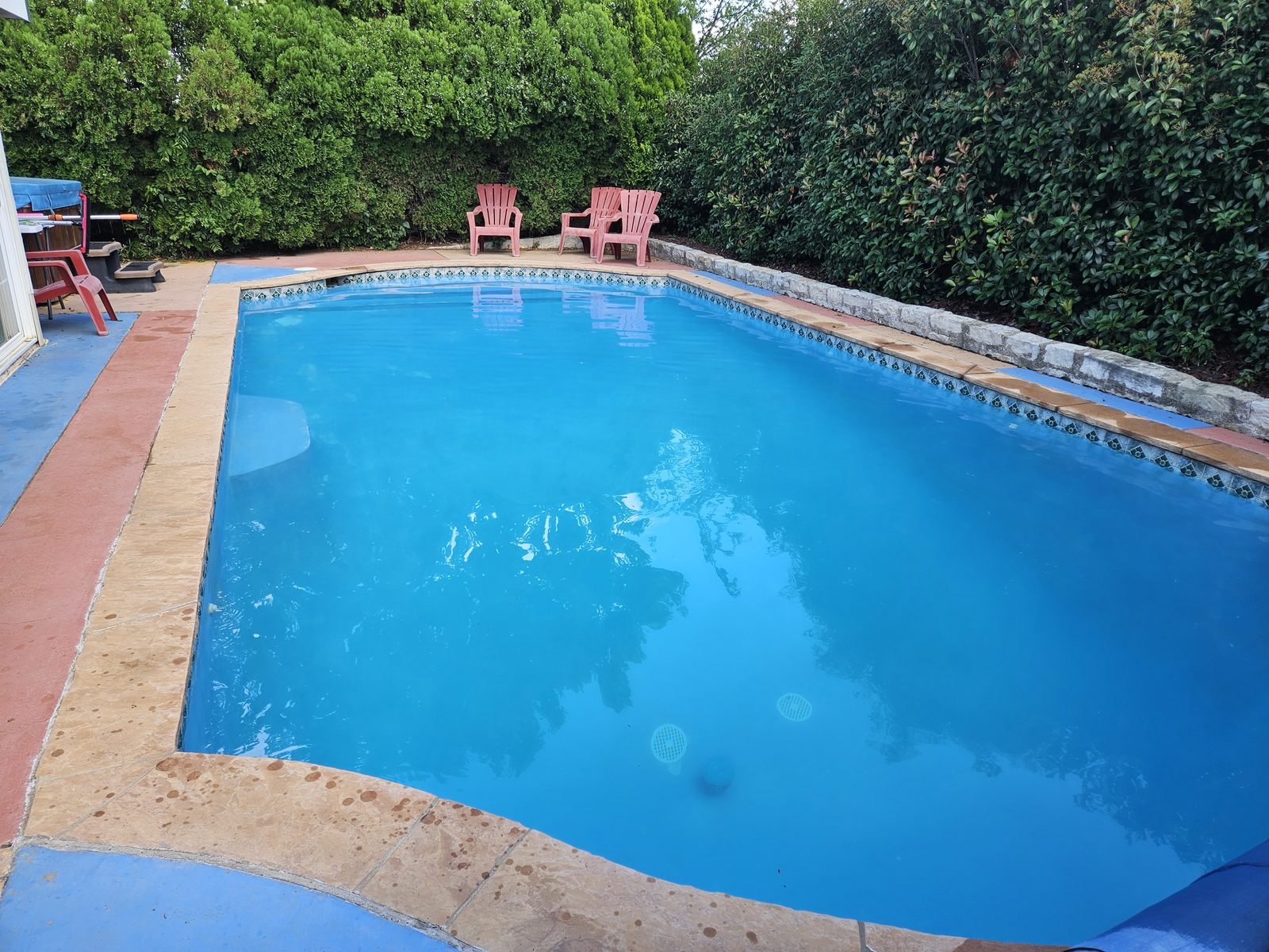 Clean, clear pool water beside a brick paver deck